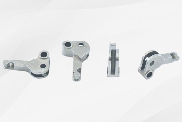 Four metal mechanical parts are arranged in a line on a white background, showing different angles and cuts of the components.