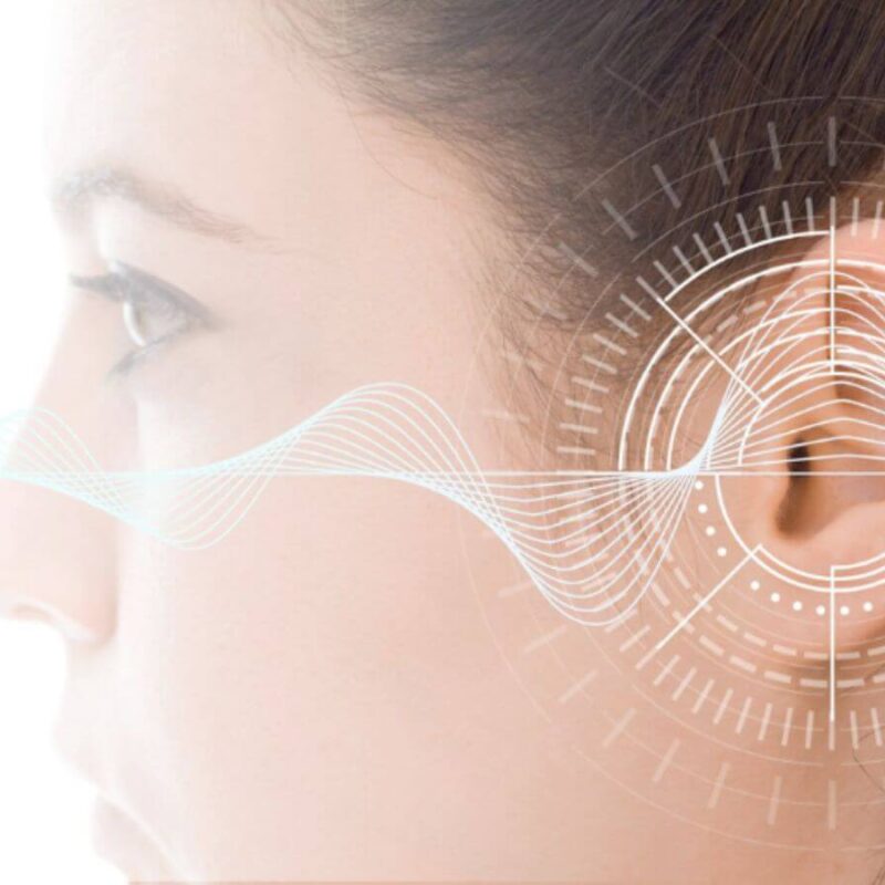 Close-up side view of a person's ear with a series of digital waveforms and circular diagram overlays, implying a concept related to hearing or audio technology.