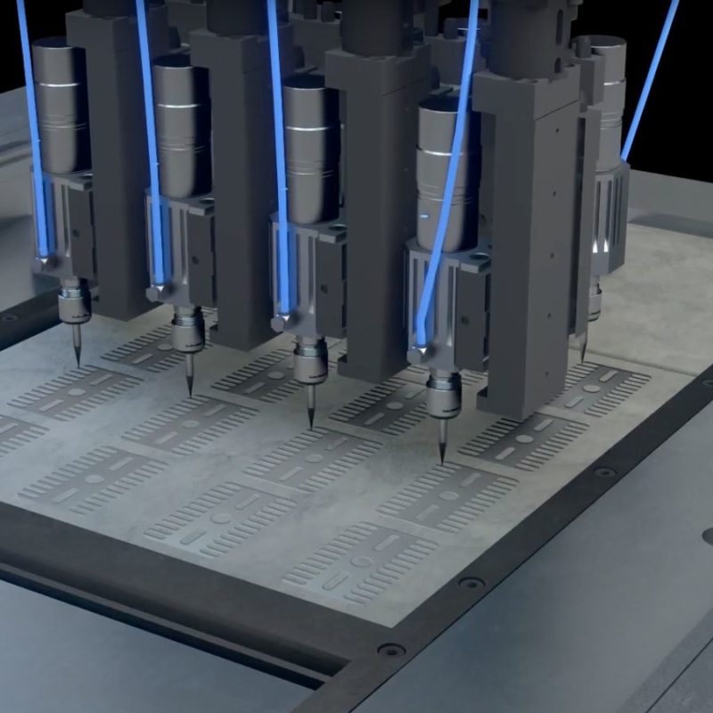 Multiple industrial robotic arms simultaneously engraving detailed patterns on a metal sheet.