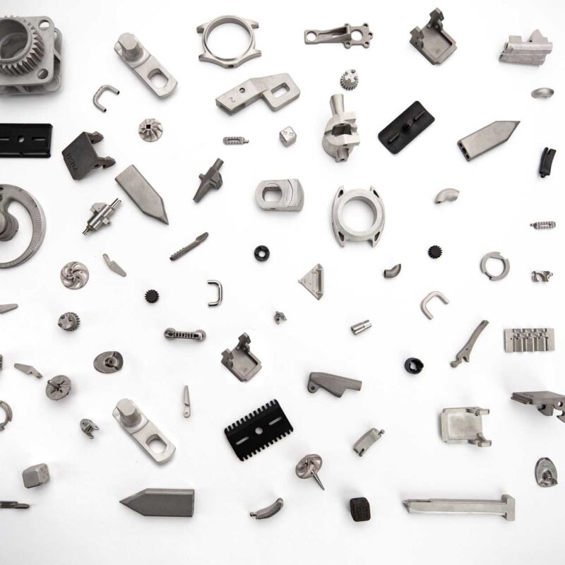 An assortment of various metal parts and components arranged randomly on a white background.