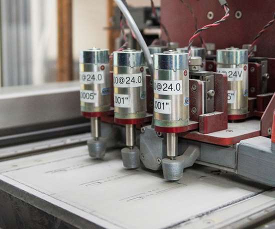 Precision machinery with multiple cylindrical components labeled at 24v, engaged in industrial manufacturing.