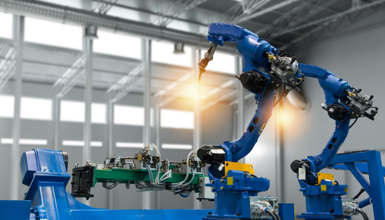 Robotic arms welding car parts on a production line in an industrial setting.