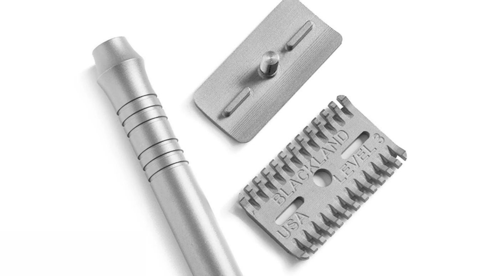 Metallic barber tools including a razor handle, blade holder, and hair thinning razor blade on a white background.